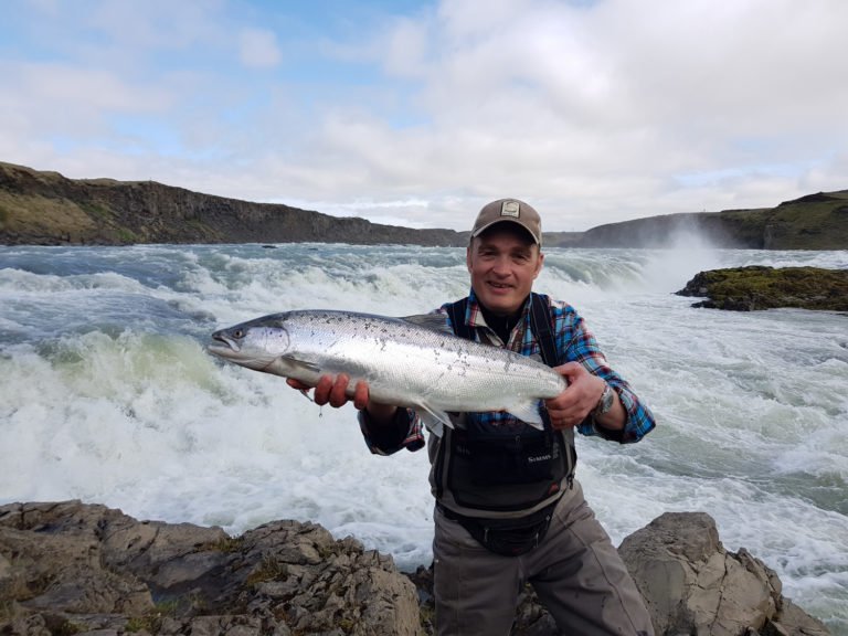 The thrill of hooking a large Atlantic salmon is evident on the face of this excited fisherman
